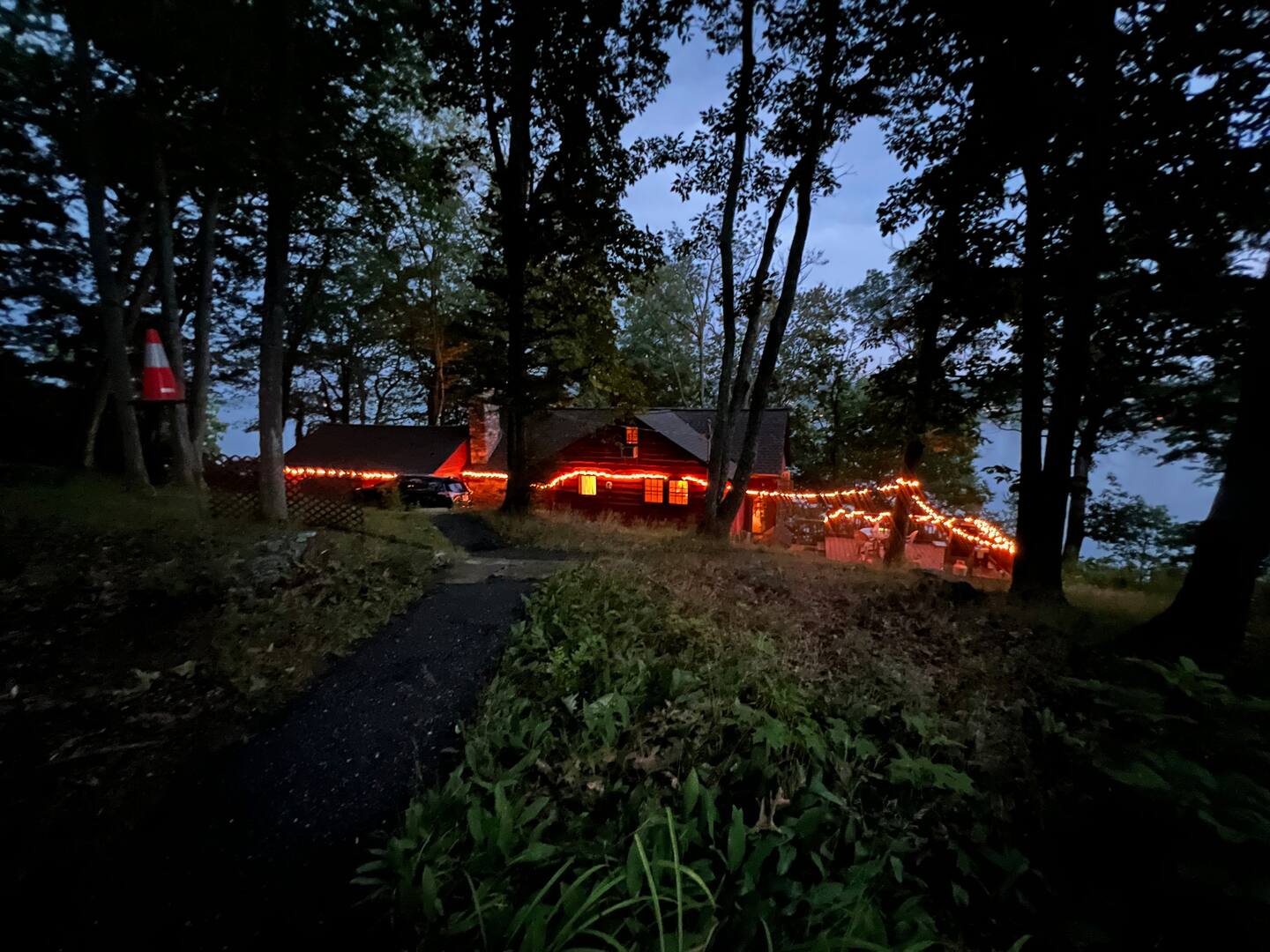 Lake house at dusk strung with warm lights